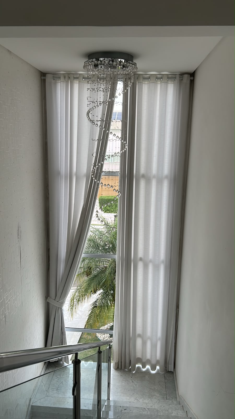 Cortinas claras de pé-direito em ambiente iluminado